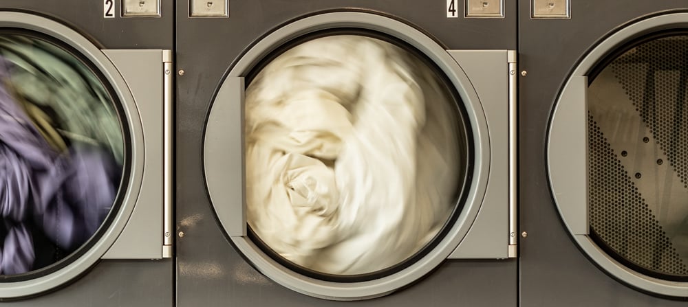 Laundry spinning  in 3 machines alongside each other
